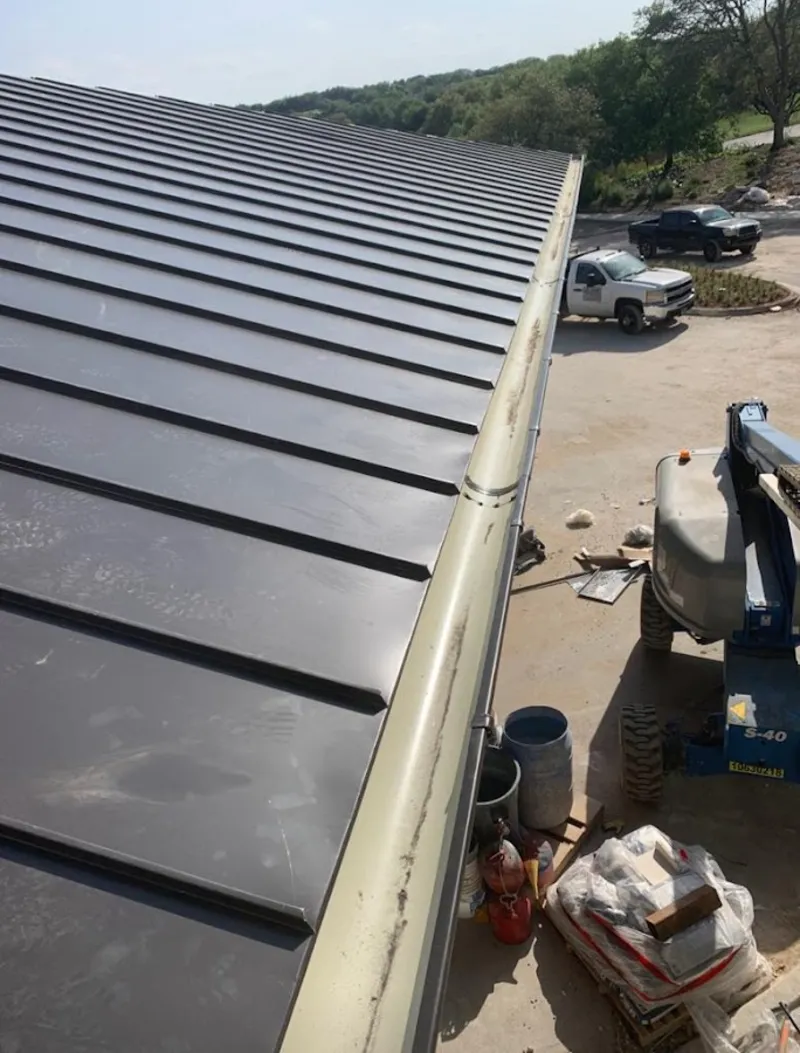 Standing seam panel and gutter detail on a metal roofing jobsite in New Braunfels
